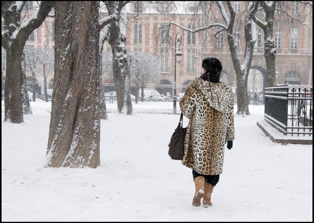 Woman walking through snow in leopard coat, Paris, France, © Hinda Schuman